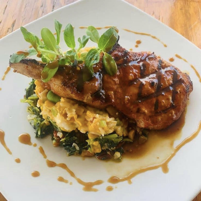 Muscadine Glazed Bone In Pork Chop, Smoked Gouda, Corn Maque Choux , Toasted Pecan Collards.