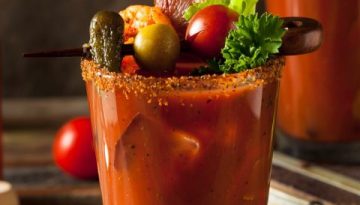 Bloody Mary in a glass with bacon, olives, garnishes