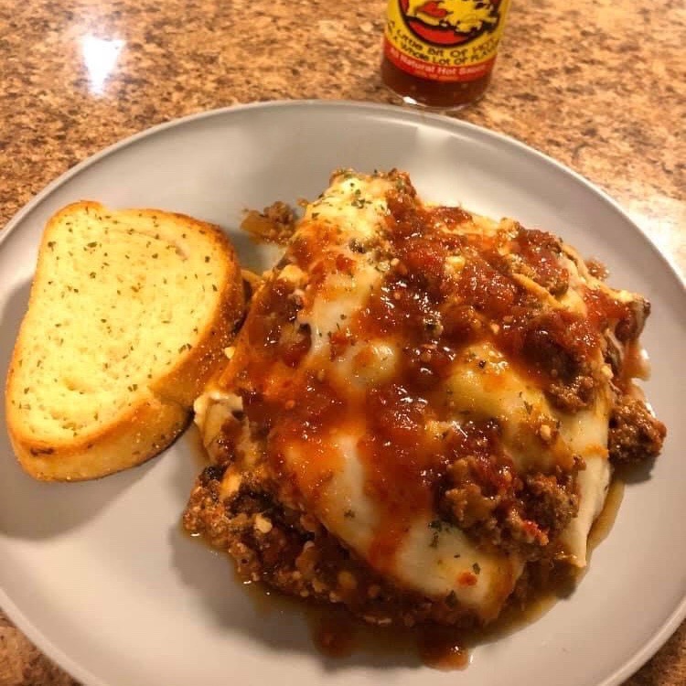 Plate of lasagna made with Dat Sauce with garlic bread.