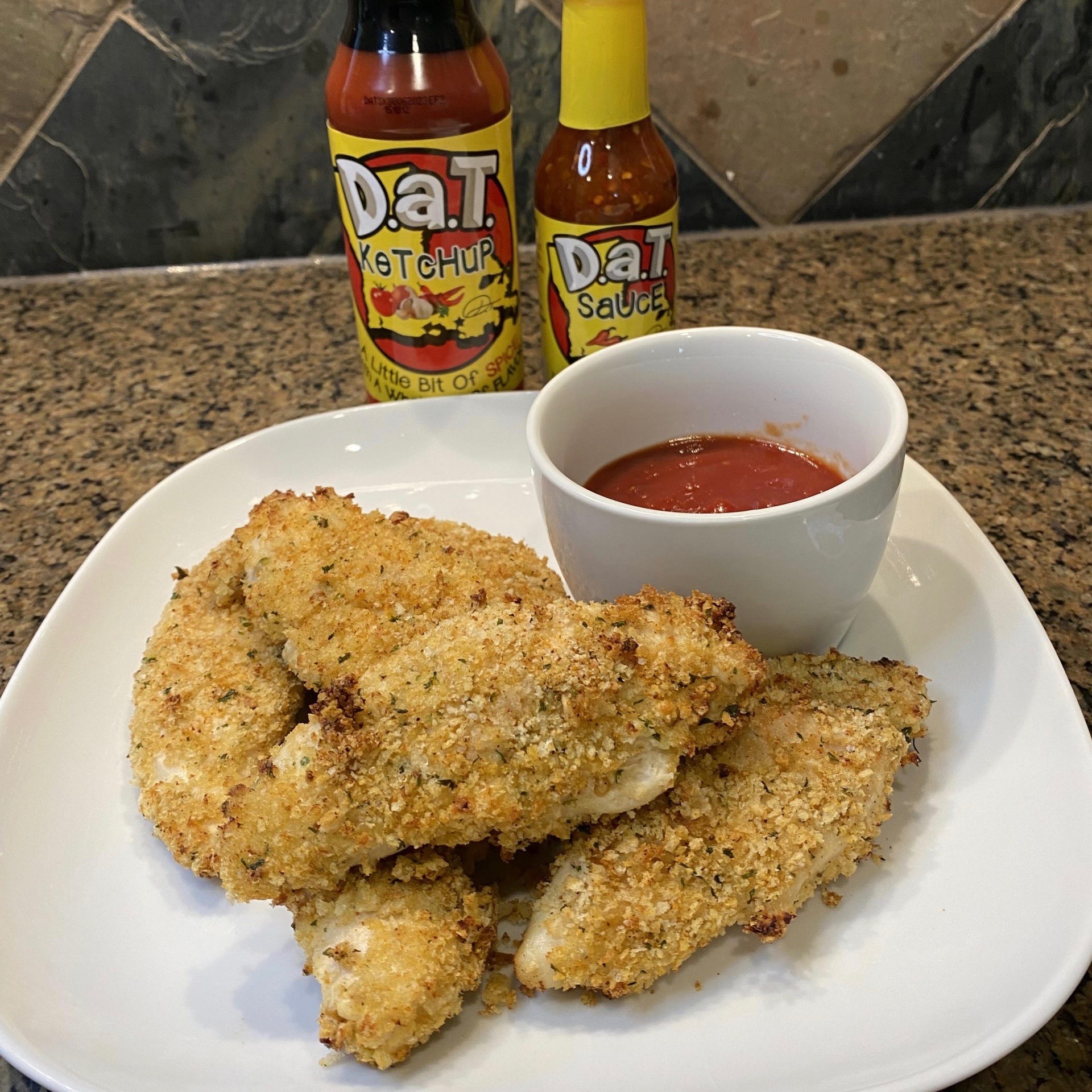 Photo of air fried chicken wings with a bottle of Dat Sauce and Dat Ketchup